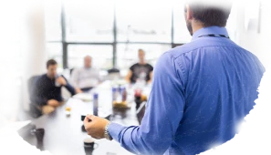 Business professional giving a presentation during an office team meeting