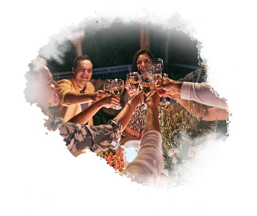 Group of friends raising wine glasses during a dinner celebration and social gathering