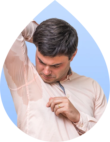 Man checking a large underarm sweat stain on his shirt caused by excessive sweating