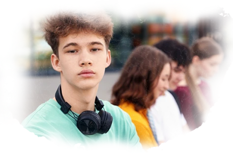 Teenage boy with headphones showing signs of social anxiety in a school environment