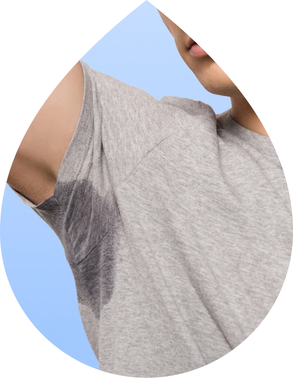 Person showing underarm sweat stain on gray shirt caused by excessive sweating