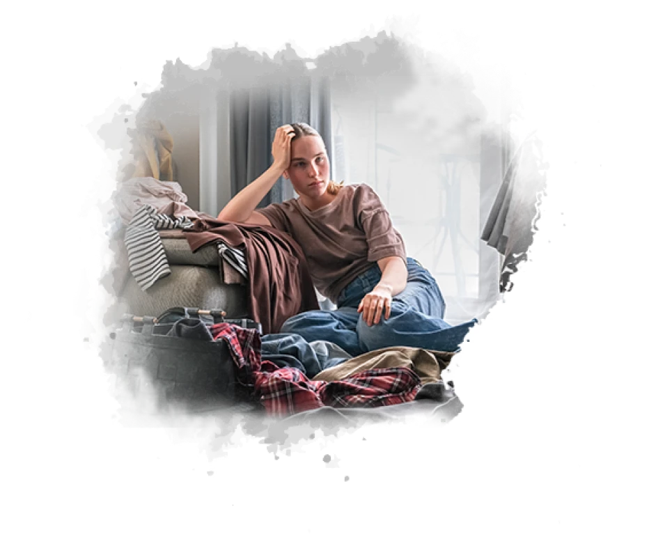 Woman sitting in bedroom feeling stressed and emotionally overwhelmed with daily life challenges
